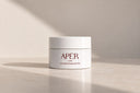 Apér Labs The Brightening Butter jar on a sunlit stone surface